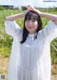 A woman in a white dress standing in a field.