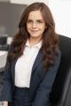 A woman in a business suit sitting in an office chair.