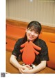 A woman sitting at a table holding a stuffed animal.