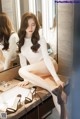 A woman sitting on a counter in front of a mirror.